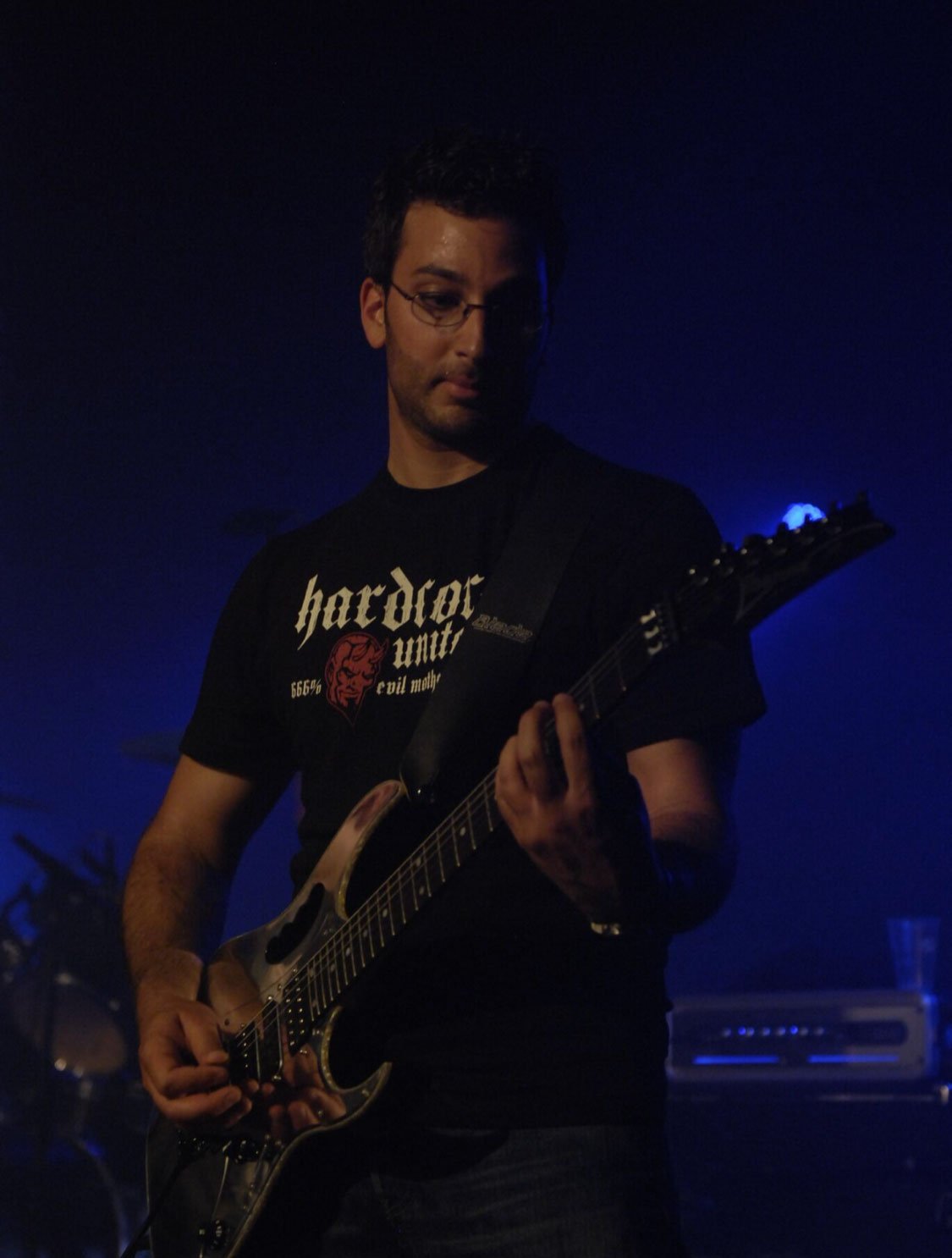 Chris en concert sur scène, guitare en main